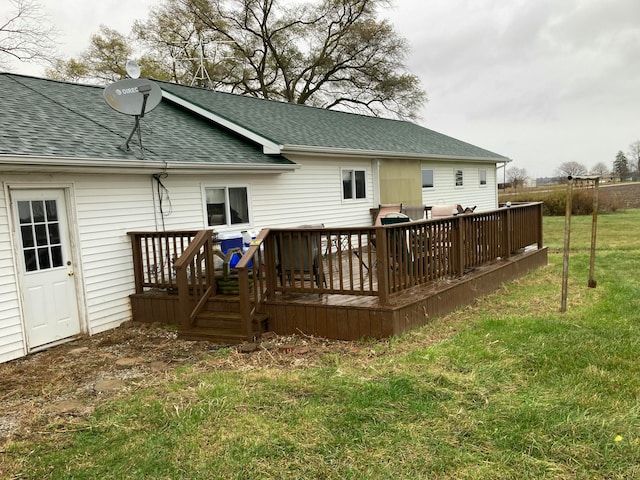 rear view of house with a lawn and a wooden deck