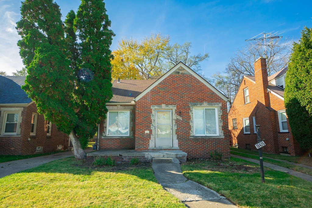 bungalow-style home with a front yard