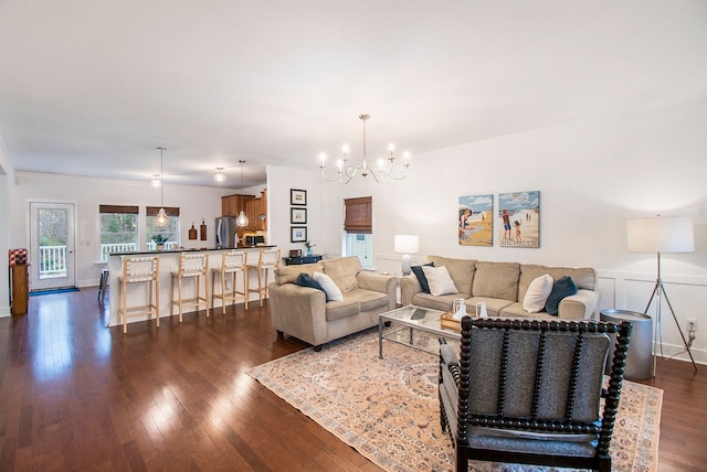 living room featuring a notable chandelier and dark hardwood / wood-style floors