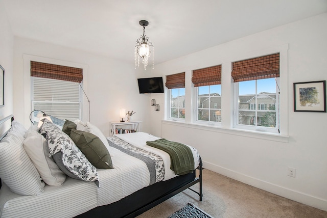 bedroom with carpet and a notable chandelier