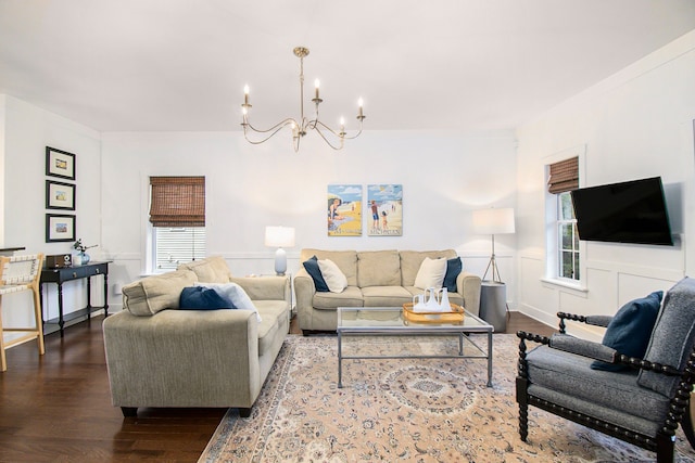 living room with plenty of natural light, a notable chandelier, and hardwood / wood-style flooring