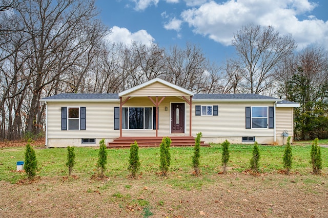 manufactured / mobile home with covered porch and a front lawn