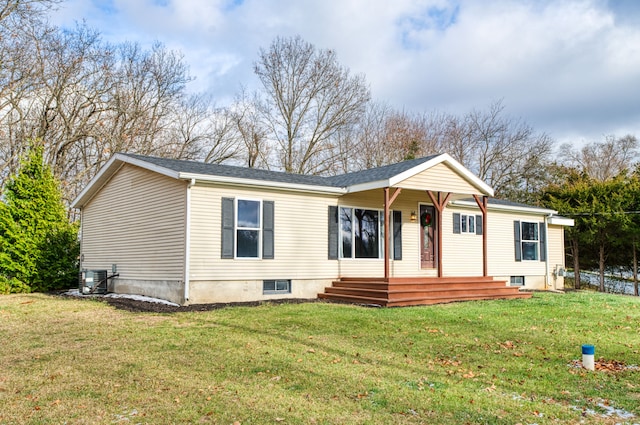 view of front of home with cooling unit and a front yard