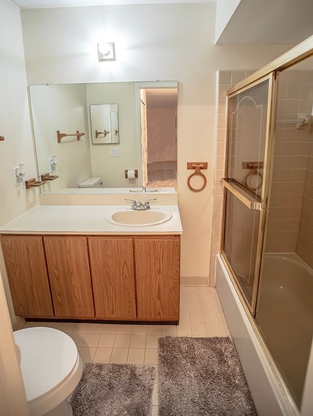 full bathroom featuring enclosed tub / shower combo, vanity, tile patterned floors, and toilet