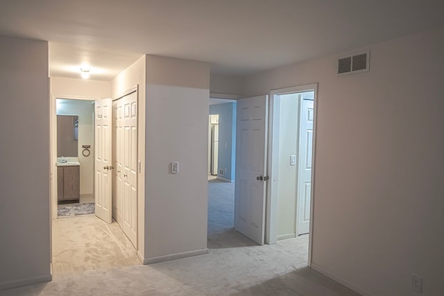 corridor featuring light colored carpet and sink