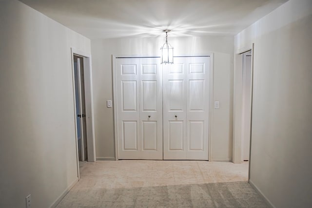 corridor featuring light colored carpet