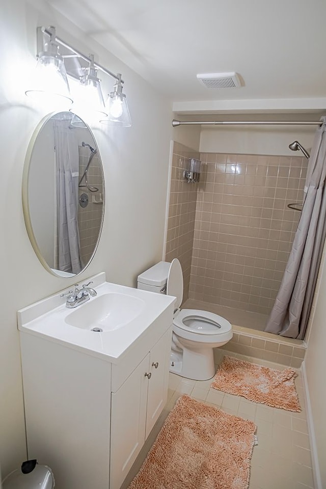 bathroom with vanity, toilet, tile patterned floors, and walk in shower