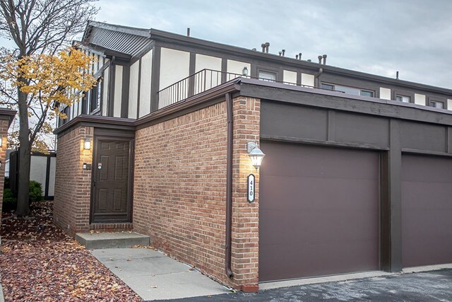 view of front facade featuring a garage and a balcony