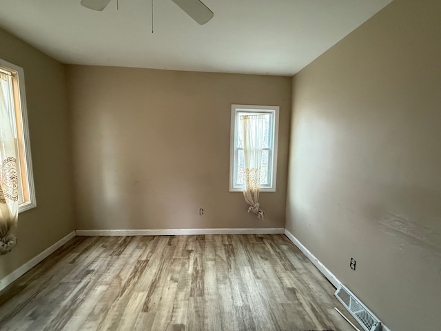 empty room with ceiling fan and light hardwood / wood-style floors