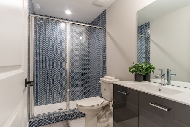 bathroom featuring vanity, toilet, and a shower with door