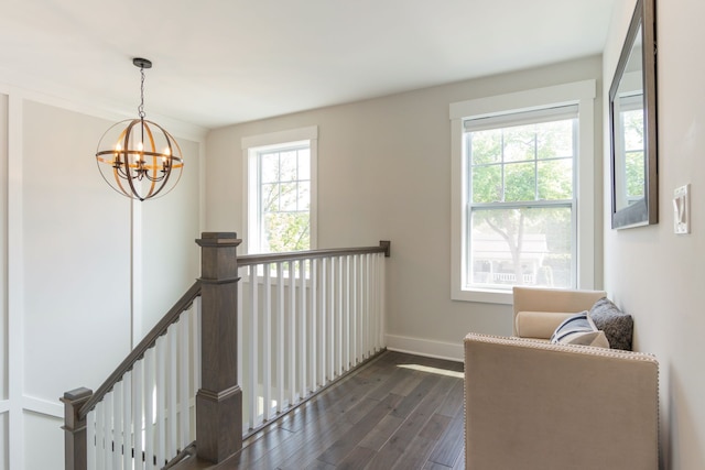 sitting room with a notable chandelier, dark hardwood / wood-style floors, and a wealth of natural light