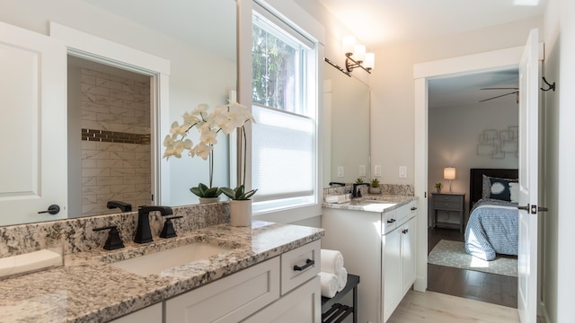 bathroom featuring hardwood / wood-style flooring, vanity, and ceiling fan with notable chandelier