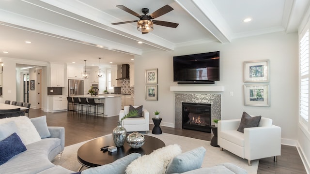 living room with beam ceiling, light hardwood / wood-style flooring, and a healthy amount of sunlight