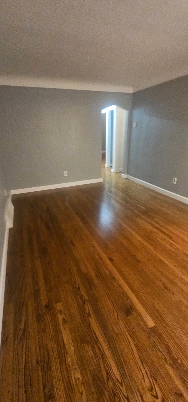 unfurnished room featuring a textured ceiling and dark hardwood / wood-style floors