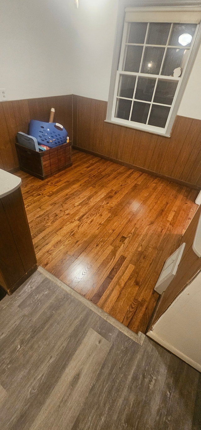 stairs with hardwood / wood-style floors and wood walls