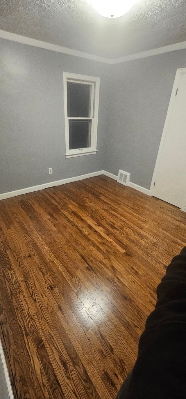 unfurnished room with wood-type flooring and a textured ceiling