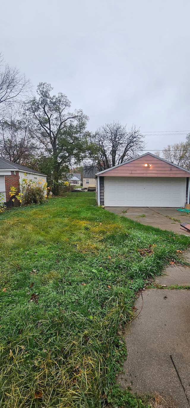 view of yard with a garage and an outbuilding