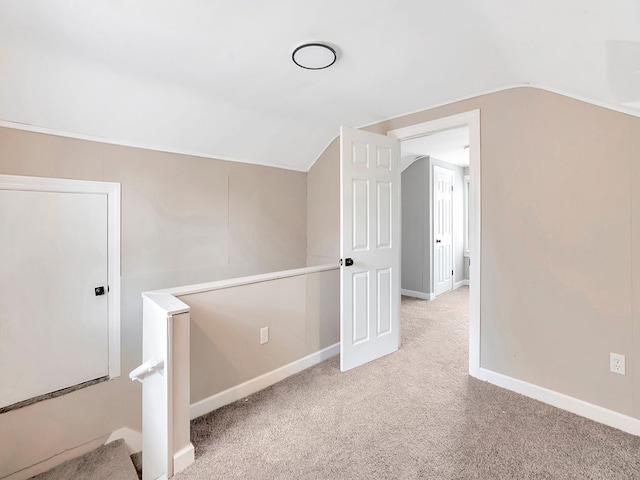 additional living space featuring light carpet and vaulted ceiling