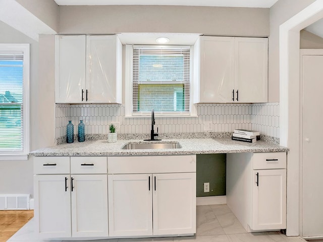 kitchen with white cabinets, a healthy amount of sunlight, and sink