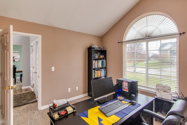 office area with light hardwood / wood-style floors and lofted ceiling