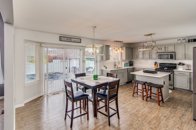 dining area featuring light hardwood / wood-style floors, sink, and a wealth of natural light