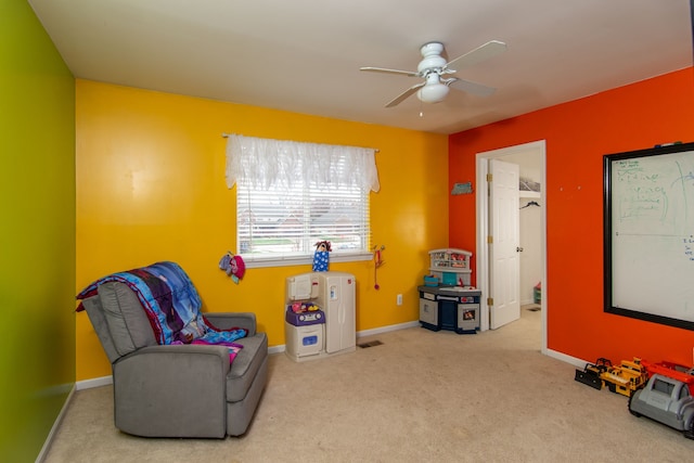 living area with light colored carpet and ceiling fan