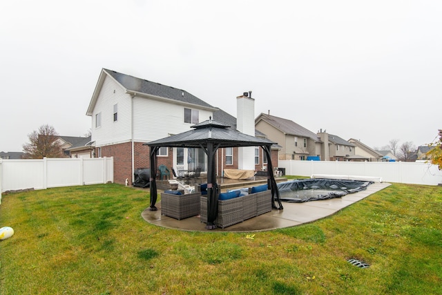 back of property with a gazebo, an outdoor living space, a patio area, and a lawn