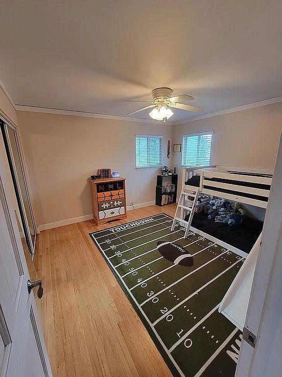 bedroom featuring hardwood / wood-style floors, ceiling fan, and ornamental molding