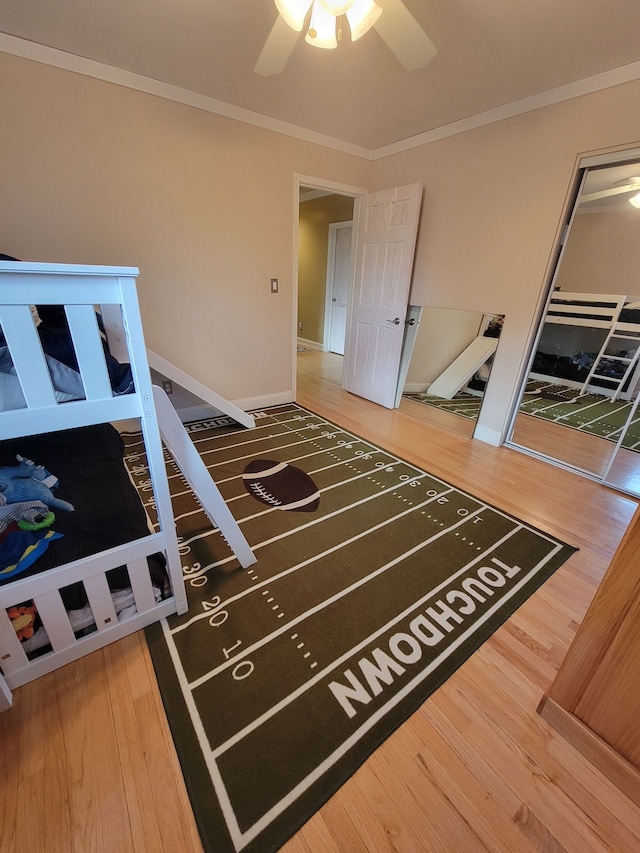 bedroom featuring hardwood / wood-style floors, ceiling fan, and crown molding