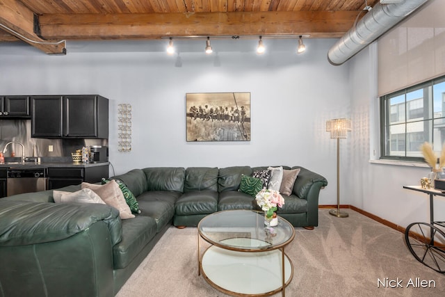 living room featuring beamed ceiling, carpet, sink, and wood ceiling