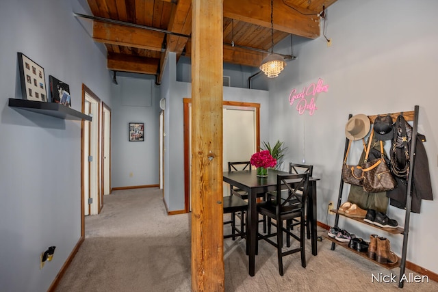 dining area featuring beam ceiling, light carpet, wooden ceiling, and a notable chandelier