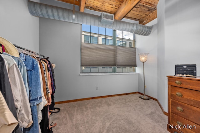 walk in closet featuring beam ceiling and light colored carpet