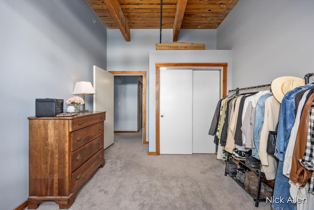 spacious closet featuring beamed ceiling and light colored carpet