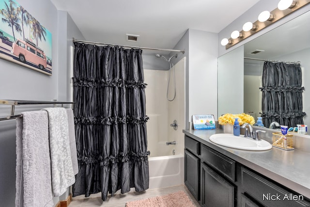 bathroom featuring hardwood / wood-style floors, shower / bath combo, and vanity