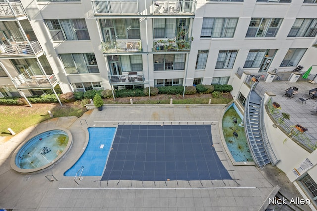 view of pool with a hot tub