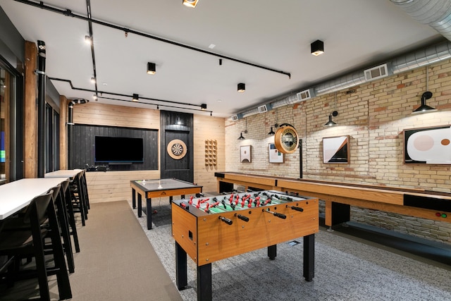 game room with light colored carpet and brick wall