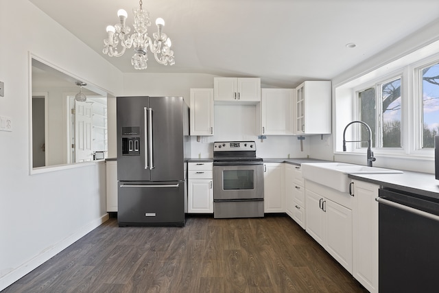 kitchen with sink, dark hardwood / wood-style flooring, pendant lighting, white cabinets, and appliances with stainless steel finishes