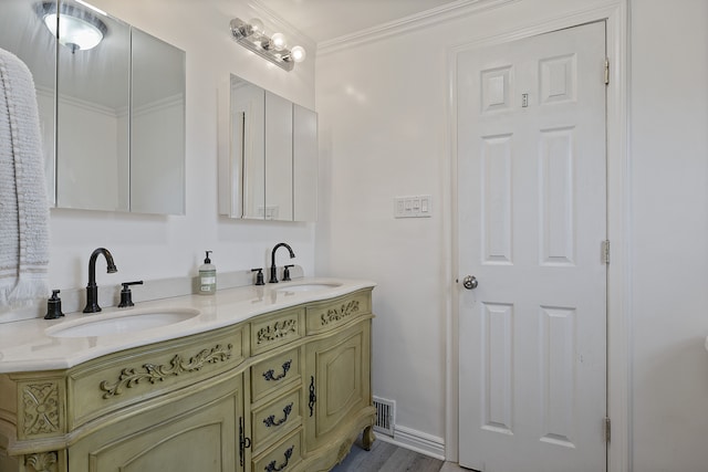 bathroom with crown molding, vanity, and hardwood / wood-style flooring