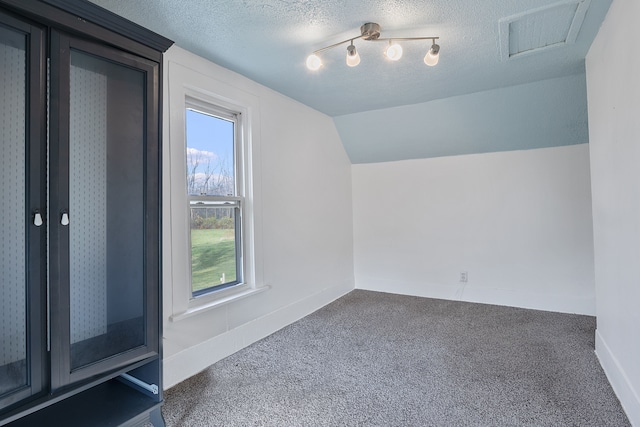 bonus room featuring dark colored carpet, a textured ceiling, and vaulted ceiling