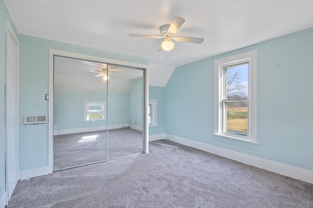 unfurnished bedroom with ceiling fan, a closet, carpet floors, and vaulted ceiling