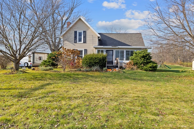 view of front of house with a front lawn and a sunroom