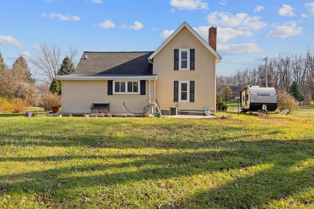 rear view of house featuring a yard and a storage shed