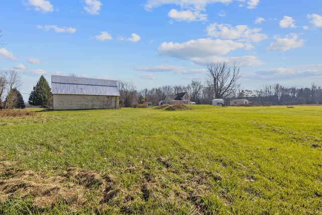 view of yard with an outbuilding and a rural view