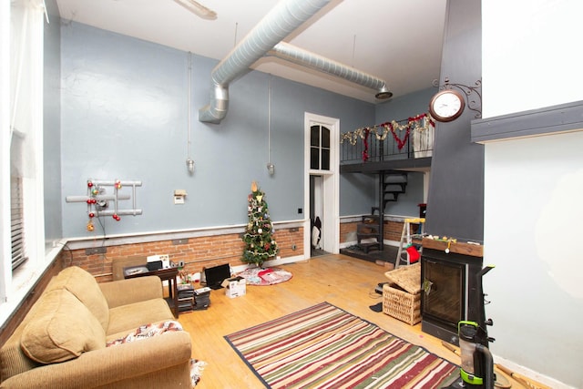 living room featuring hardwood / wood-style flooring and brick wall