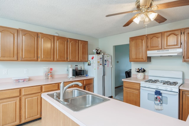 kitchen with a textured ceiling, ceiling fan, white appliances, and sink