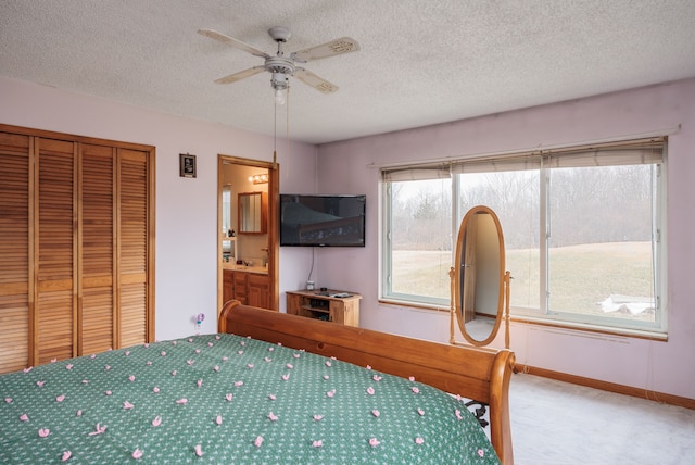 unfurnished bedroom with ceiling fan, ensuite bathroom, and a textured ceiling