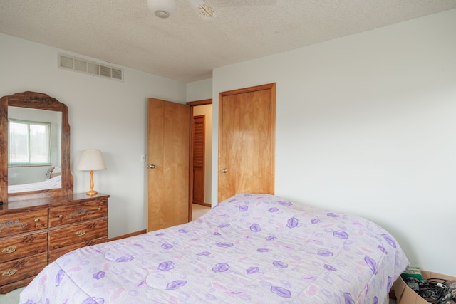 bedroom with a textured ceiling and ceiling fan