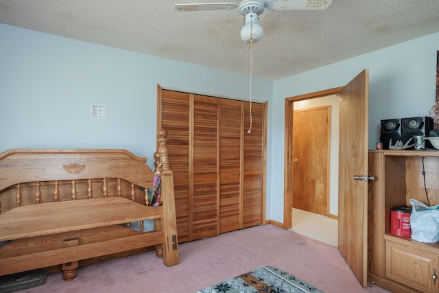 bedroom featuring carpet, a textured ceiling, a closet, and ceiling fan