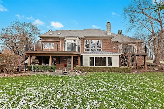 rear view of property with a lawn, a patio, a fire pit, and a deck