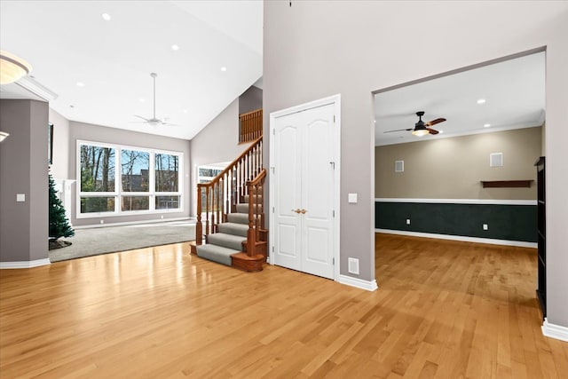 unfurnished living room with ceiling fan, light hardwood / wood-style flooring, and high vaulted ceiling